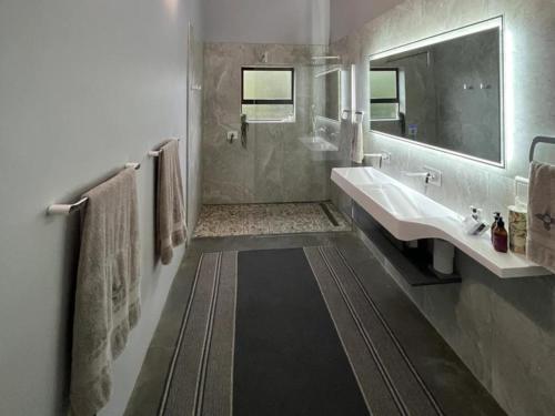 a bathroom with a tub and a sink and a mirror at Zia Cottage in Wolseley