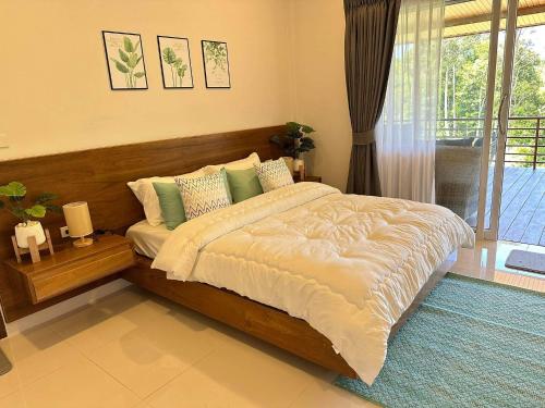 1 dormitorio con 1 cama grande y balcón en The Little Waterfall Phangan, en Thong Nai Pan Noi