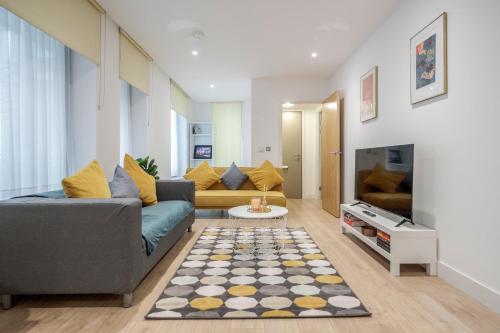 a living room with a couch and a tv at Deluxe Condo Beside 02 Arena and Central London in London