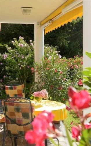 a table and chairs with flowers on a patio at Apparthaus Vonbank in Schruns-Tschagguns