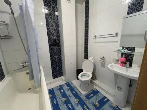 a bathroom with a toilet and a sink at Three bedroom apartment with 2 showers in Tashkent