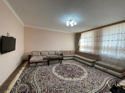 a living room with a couch and a large rug at Three bedroom apartment with 2 showers in Tashkent
