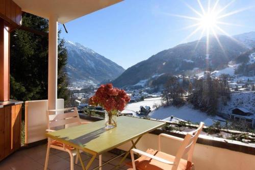 a table with a vase of flowers on a balcony at Apparthaus Vonbank in Schruns-Tschagguns