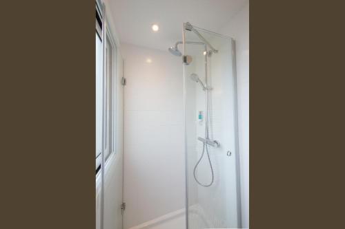 a shower with a glass door in a bathroom at La Regence in Courbevoie