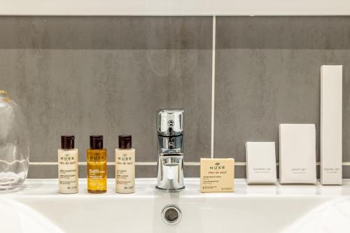 a shelf with a bottle of perfume and candles at Sweet Inn - Ponthieu V in Paris