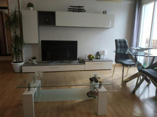 a living room with a tv and a glass table at Bedroom to rent in the beach in Valencia