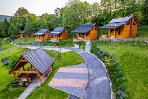 una fila de cabañas de madera con paneles solares en sus tejados en Domki pod Jaworem Brenna, en Brenna