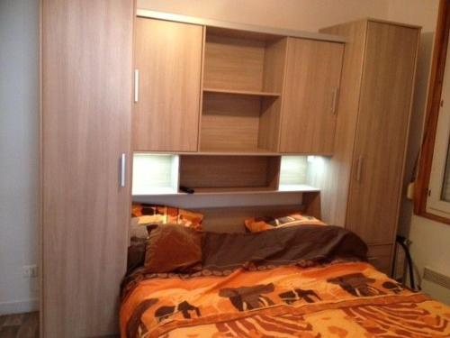 - une chambre avec un lit et des placards en bois dans l'établissement Détente à Le Portel, à Le Portel