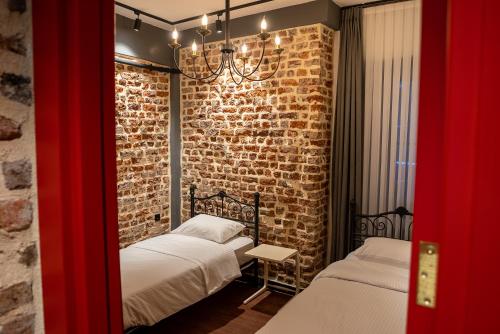イスタンブールにあるAlness Residenceのレンガの壁、ベッド2台が備わるベッドルーム1室が備わります。