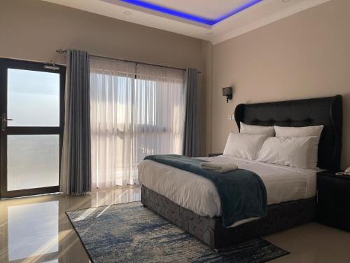 ein Schlafzimmer mit einem Bett und einem großen Fenster in der Unterkunft The Ace Hotel in Lusaka