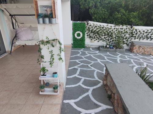 a patio with potted plants and a couch at Aegean Blue in Panteli