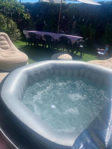 un bain à remous avec une table et une table et des chaises dans l'établissement chez Natalie et Serge, à Lannion