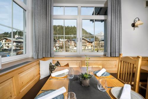 a dining room with a table and a large window at Hotel Jagdhof in Filzmoos