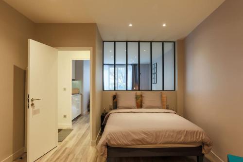 ein Schlafzimmer mit einem Bett und einem großen Fenster in der Unterkunft 2 pieces proche metro, Montrouge in Montrouge