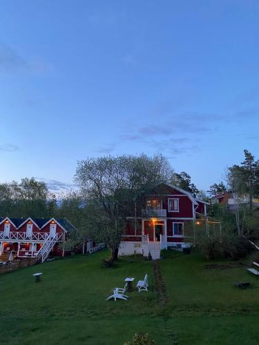 a house with two lawn chairs in the yard at Ljusterö Logi in Norra Ljustero