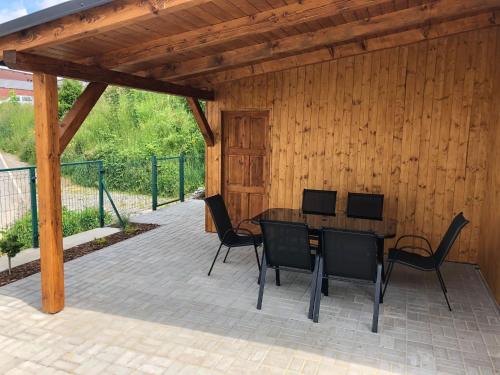 eine Holzterrasse mit einem Holztisch und Stühlen in der Unterkunft Papeto in Frymburk