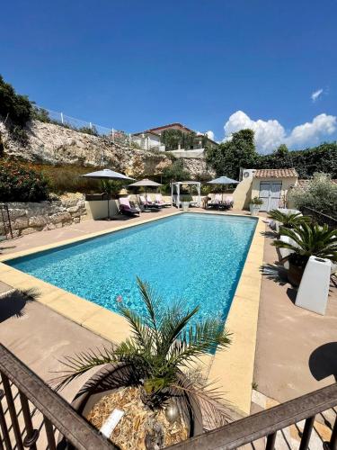 une piscine avec chaises et parasols dans l'établissement Villa fiora classée 4 étoiles, à Martigues