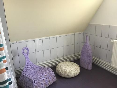 three purple vases sitting on the floor in a bathroom at Villa Siret in Galaţi