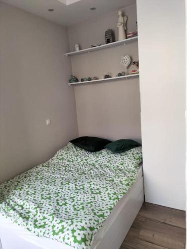 a small bed in a corner of a room at Apartament w sercu Malborka in Malbork