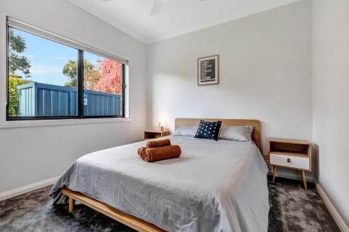 a bedroom with a bed with a large window at Velo Station in Porepunkah