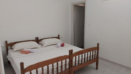 a bedroom with a wooden bed with two pillows at Antoni Apartment in Lastovo