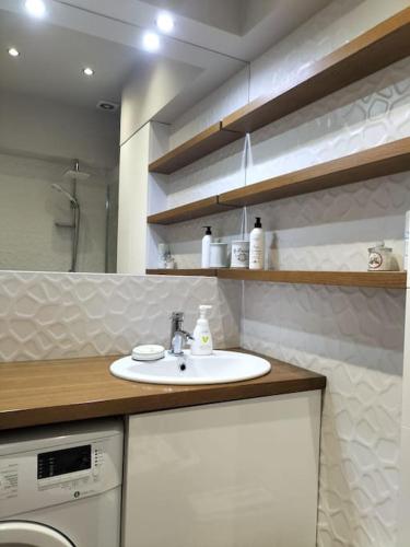a bathroom with a sink and a washing machine at Apartament w sercu Malborka in Malbork