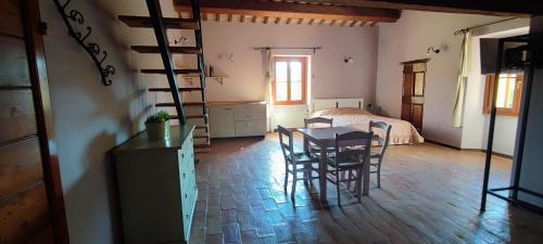 a room with a table and chairs and a bed at Tenuta Le Garzaie - Villa Furlo in Fermignano