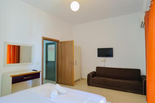 sala de estar con cama y sofá en Hotel Argjiro en Sarandë