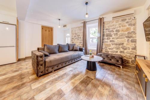 ein Wohnzimmer mit einem Sofa und einem Tisch in der Unterkunft Happy Home Apartments in Kotor