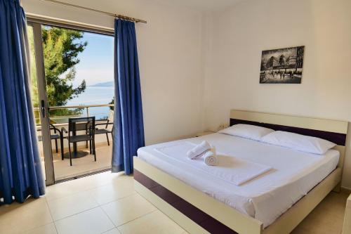 Schlafzimmer mit einem Bett und Meerblick in der Unterkunft Hotel Argjiro in Sarandë