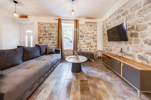 ein Wohnzimmer mit einem Sofa und einem TV in der Unterkunft Happy Home Apartments in Kotor