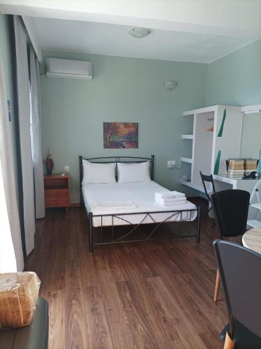 una stanza con un letto, un tavolo e delle sedie di Beachfront apartment a Rethymno