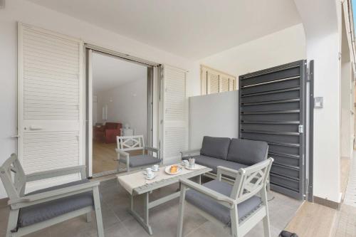 uma sala de estar com mesa e cadeiras em Villino Terracielo by BarbarHouse em Torre Lapillo