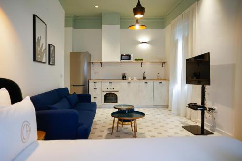 a living room with a blue couch and a tv at Casa Alberola Apartments in Alicante