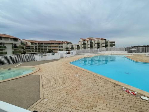 une grande piscine devant certains immeubles d'habitation dans l'établissement Résidence les Goélettes, logement RDC à 30 m de la plage, à Saint-Cyprien