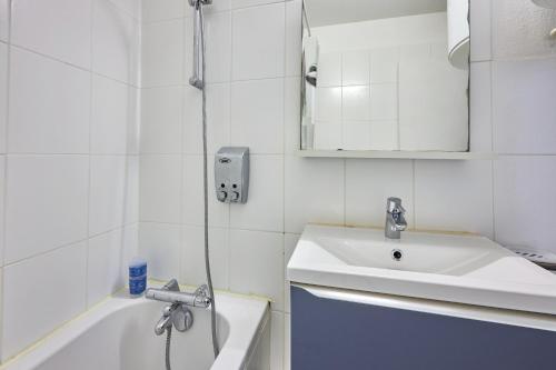 une salle de bain blanche avec un lavabo et une douche dans l'établissement Galys - Appt à 1 km de la plage, à Courseulles-sur-Mer