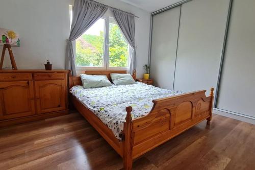 sypialnia z drewnianym łóżkiem i oknem w obiekcie ILIS House Matka w mieście Skopje