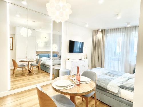 1 dormitorio con 1 cama, mesa y sillas en Ocean Dream en Międzyzdroje