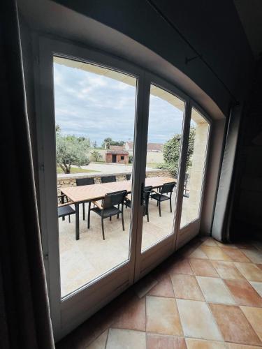 a room with a large window with a table and benches at Le Mas de Maellou - Maison de vacances en Drôme Provençale in Grillon