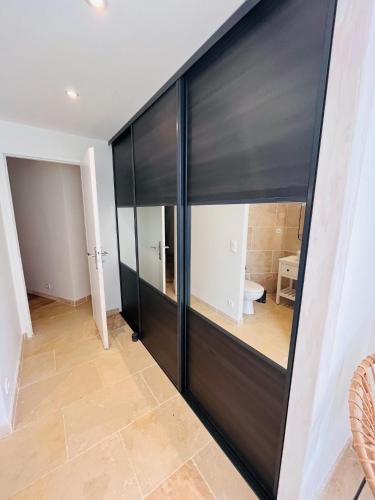 a large black sliding door in a room with a toilet at Le Mas de Maellou - Maison de vacances en Drôme Provençale in Grillon