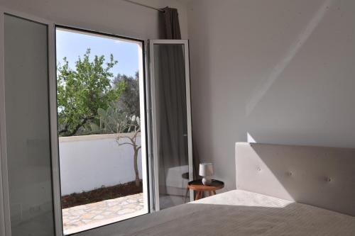 Schlafzimmer mit einer großen Glastür zu einem Balkon in der Unterkunft Villa Rachele in Sant'Isidoro
