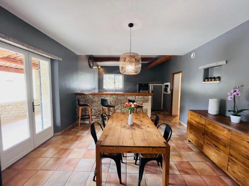 a dining room with a wooden table and chairs at Le Mas de Maellou - Maison de vacances en Drôme Provençale in Grillon