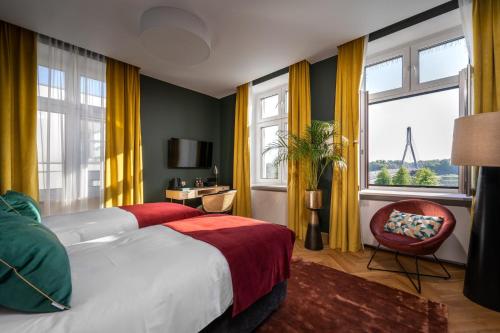 a bedroom with a bed and a chair and windows at Sava Boutique Hotel in Warsaw