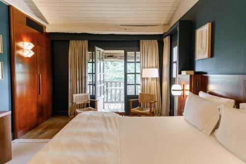 a bedroom with a large white bed with blue walls at Les Sources de Caudalie in Martillac