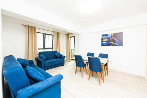 a living room with a blue couch and a table and chairs at Apart HOTEL Fusion Tower in Iaşi