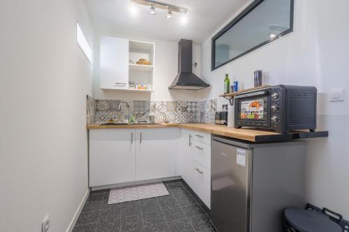 une petite cuisine avec un micro-ondes et un réfrigérateur dans l'établissement Terrazza Moriani - Charmant appartement à 500m de la mer, à San-Nicolao