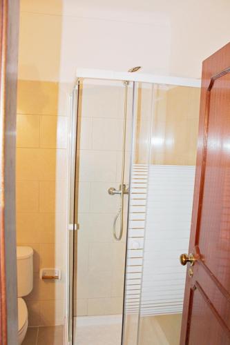 a shower with a glass door in a bathroom at Villa do Sol Carcavelos Beach House in Carcavelos