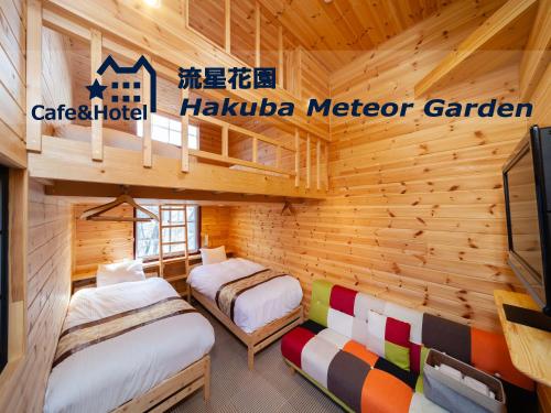 a log cabin with two beds and a tv at Meteor Garden in Hakuba