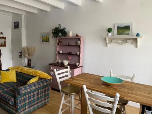 un salon avec une table et un canapé dans l'établissement Le Petit Maison, à Montembœuf