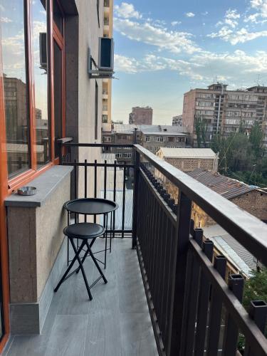 a balcony with a stool and a table on a building at Sweet Home Apart-Hotel in Yerevan